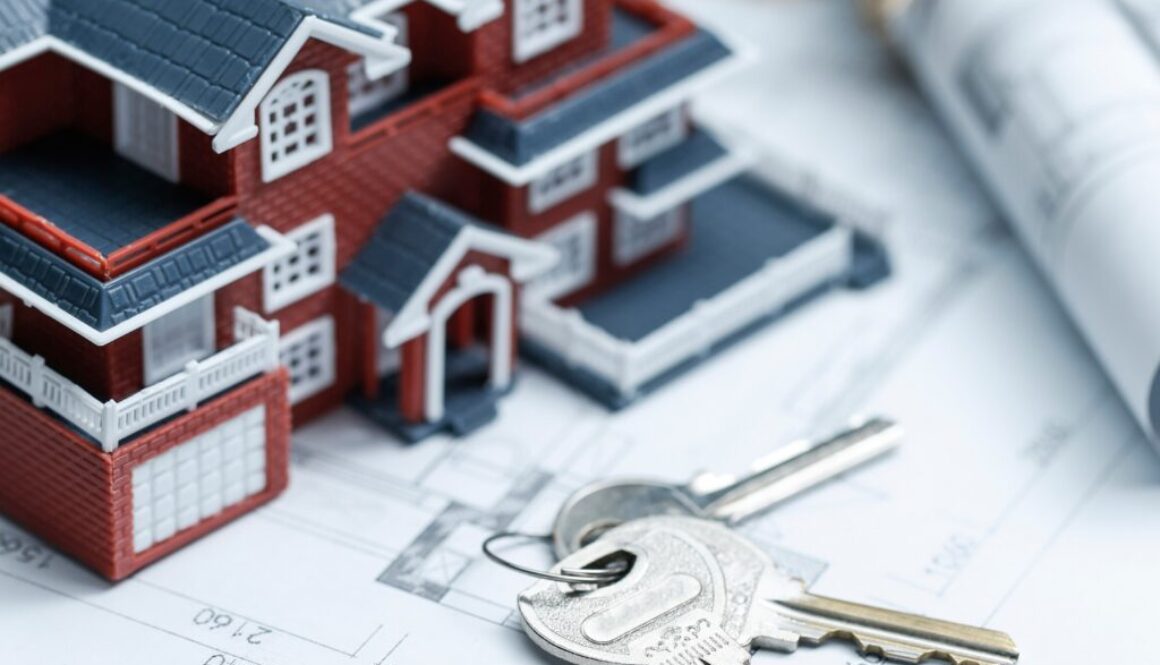 Villa house model, key and drawing on retro desktop (real estate sale concept)